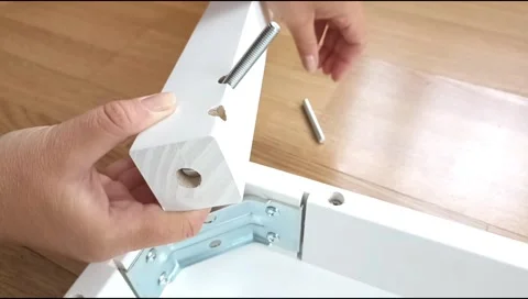 Assembly of a table leg using metal fasteners, connector pins Stock Footage 339180284