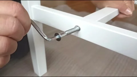 Assembly of white furniture using a hex wrench and metal bolt. Stock Footage 339176028