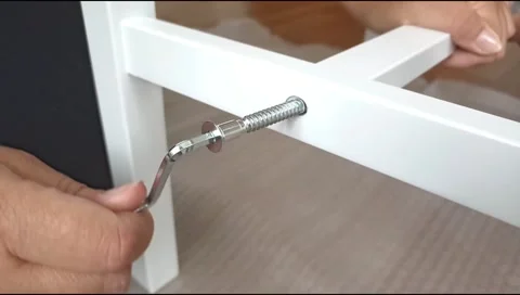 Assembly of white furniture using a hex wrench and metal bolt. Stock Footage 339176029