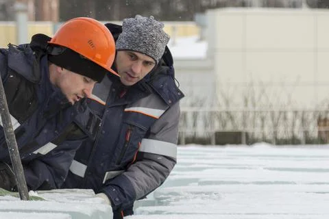 An assembly worker tries to push the ice slabs apart with a crowbar Fotos Stock