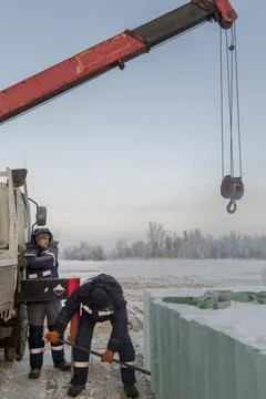 An assembly worker tries to push the ice slabs apart with a crowbar Stock-Fotos
