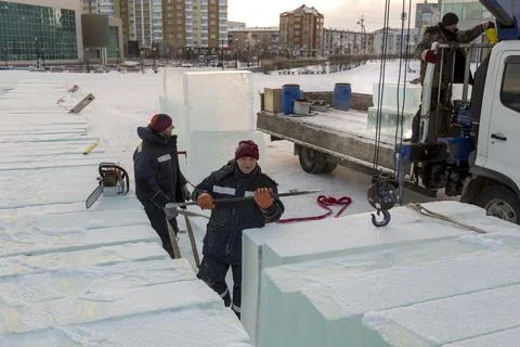 An assembly worker tries to push the ice slabs apart with a crowbar 写真素材