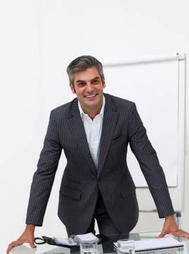 Assertive businessman leaning on a conference table Stock Photos