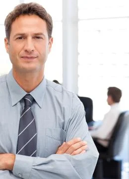 Assertive businessman standing in front of his team while working at a table Stock Photos