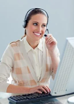 Assertive businesswoman with headset on working at a computer Stock Photos