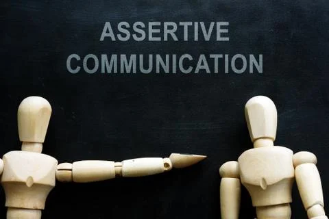 Assertive communication phrase and two wooden figures. Stock Photos