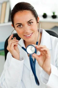 Assertive hispanic doctor holding a stethoscope at the camera Stock Photos