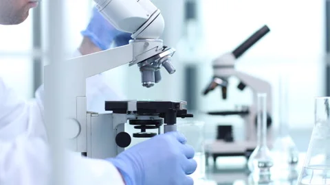 Assertive male scientist looking through a microscope Video stock 244958782