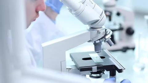 Assertive male scientist looking through a microscope Stock Footage 260422942