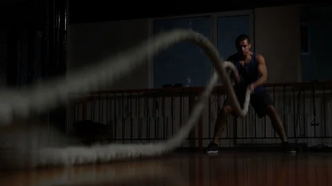 Assertive man doing exercises with battle rope, ruthlessly effective workout Stock Footage 121804950
