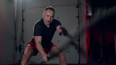 Assertive man doing exercises with battle rope, ruthlessly effective workout. Stock Footage 155660754