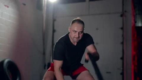 Assertive man doing exercises with battle rope, ruthlessly effective workout. Stock Footage 155660761