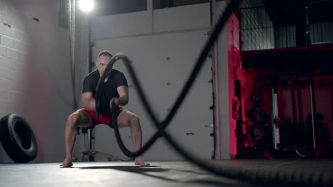 Assertive man doing exercises with battle rope, ruthlessly effective workout. Stock Footage 155660986