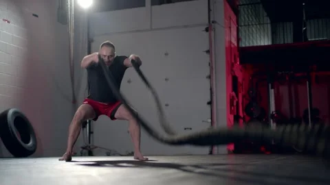 Assertive man doing exercises with battle rope, ruthlessly effective workout. Stock Footage 155661079
