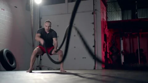 Assertive man doing exercises with battle rope, ruthlessly effective workout. 스톡 동영상 155661201