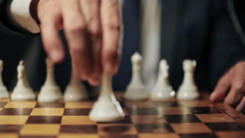 Assertive man moving queen piece along chessboard, business strategy, planning Stock Footage 160809321