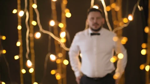 Assertive Man Posing in Room with Fairy Lights Stock Footage 108531575