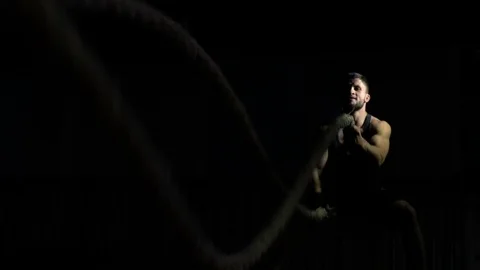 Assertive man throwing heavy battle ropes in gym, building muscles, slow-motion Stock Footage 121880969