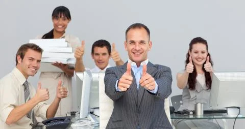 Assertive manager and his team with thumbs up Stock Photos