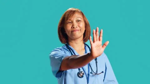 Assertive nurse throwing stop hand sign Stock Photos