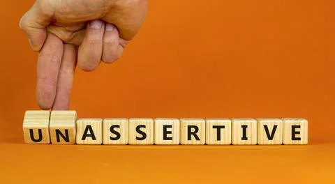 Assertive or unassertive symbol. Businessman turns wooden cubes and changes c Stock Photos
