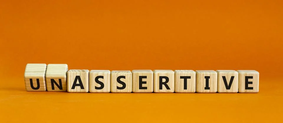 Assertive or unassertive symbol. Turned wooden cubes and changed concept word Stock Photos