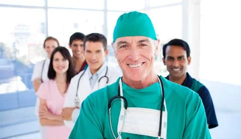 Assertive senior surgeon standing with his colleagues Stock Photos