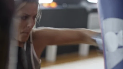 Assertive Woman Training with Punching Bag Stock Footage 87696444