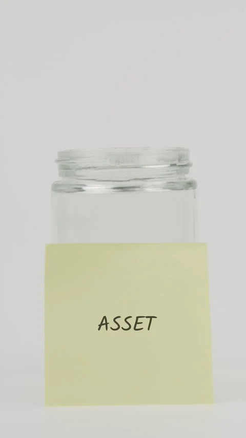 Asset text or word on yellow sticky note attached to glass jar with hand Stock Footage 311678351