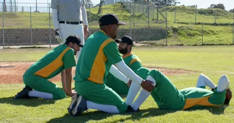 Assistant clapping starting situps with diverse male baseball players under Stock Footage 342798732