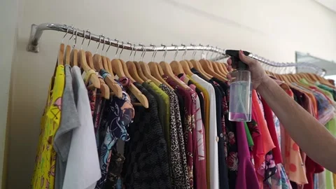 Assistant cleaning up the clothing store. Stock Footage 137676783