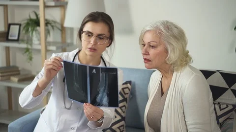Assistant of doc looking on x-ray with senior woman Stock Footage 111059851