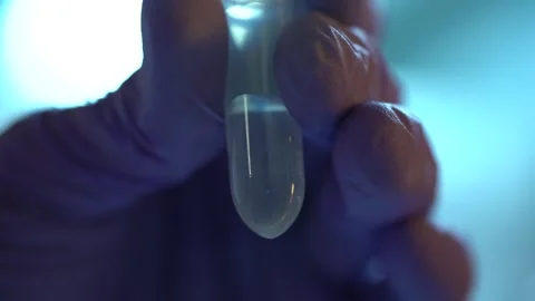 Assistant hand fills small plastic test tube with liquid in lab Stock Footage 327046762