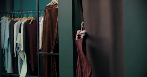 Assistant handing clothes into fitting room Stock Footage 321607856