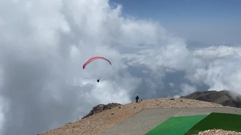 Assistant helps an instructor and a passenger launch a tandem paragliding flight Stock Footage 340181702