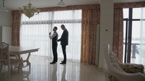 The assistant helps the man to put on a suit Video stock 131340116