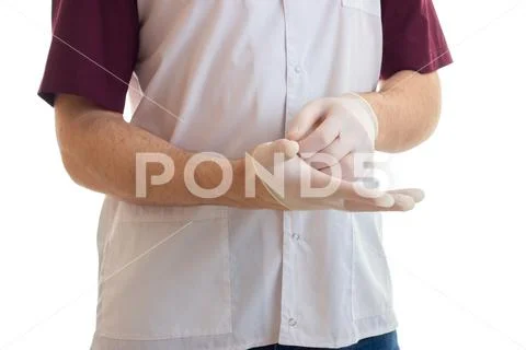 Assistant physician puts on hand gloves close-up Stock Photos