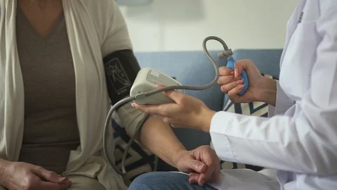 Assistant of practitioner checking pressure of mature old woman Video stock 113996989