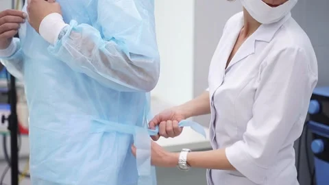 Assistant preparing doctor for future surgery operation. Stock Footage 144421398