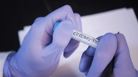 Assistant in purple gloves with coronavirus sample at table Stock Footage 127214892