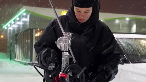 Assistant quickly assembles camera tripod on icy ground Stock Footage 308941722