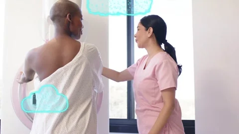 Assistant raising hands, guiding patient onto mammogram for breast scan while 動画素材 330141914