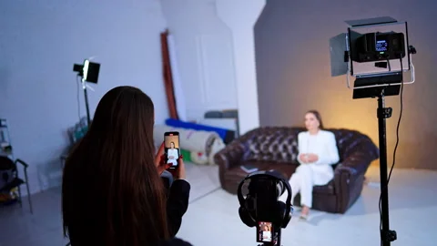 Assistant Recording Interview Subject On Smartphone In Studio. Assistant records Stock Footage 334812834