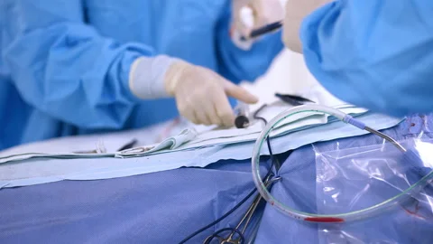 Assistant surgeon prepares instruments in rubber gloves and hands to surgeon Stock Footage 255151234