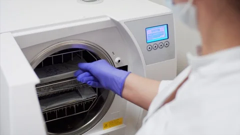 Assistant takes out pockets with sterilized dental instruments from autoclave Stock Footage 127133465