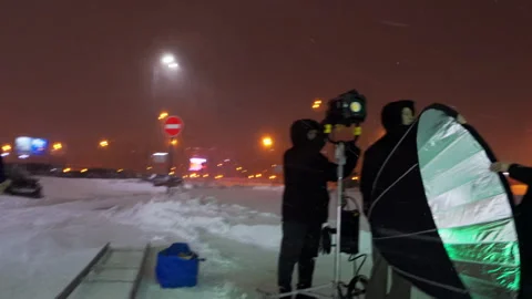 Assistants swiftly remove softbox from towering spotlight Video stock 308942635