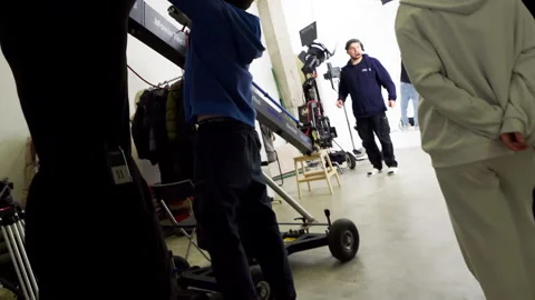 Assistants work together to assemble camera jib on set 動画素材 303064415