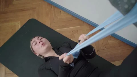 Assisted Hamstring Stretch With Resistance Band on Floor Mat Stockbeeldmateriaal 340544825