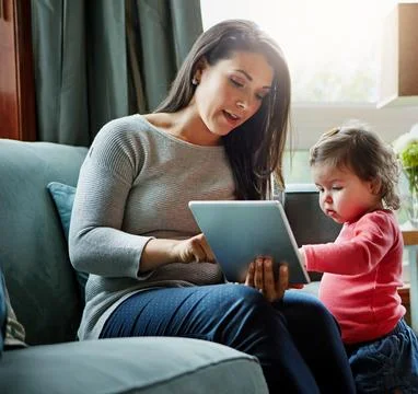 Assisting her childs learning through technology. a mother and her adorable Stock Photos