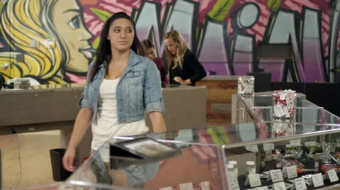 Associate at a marijuana shop uses tablet to show product to an older customer Stock Footage 58874663